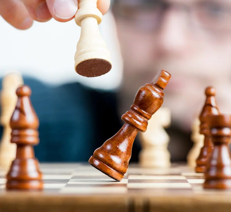 A person is playing chess on the board